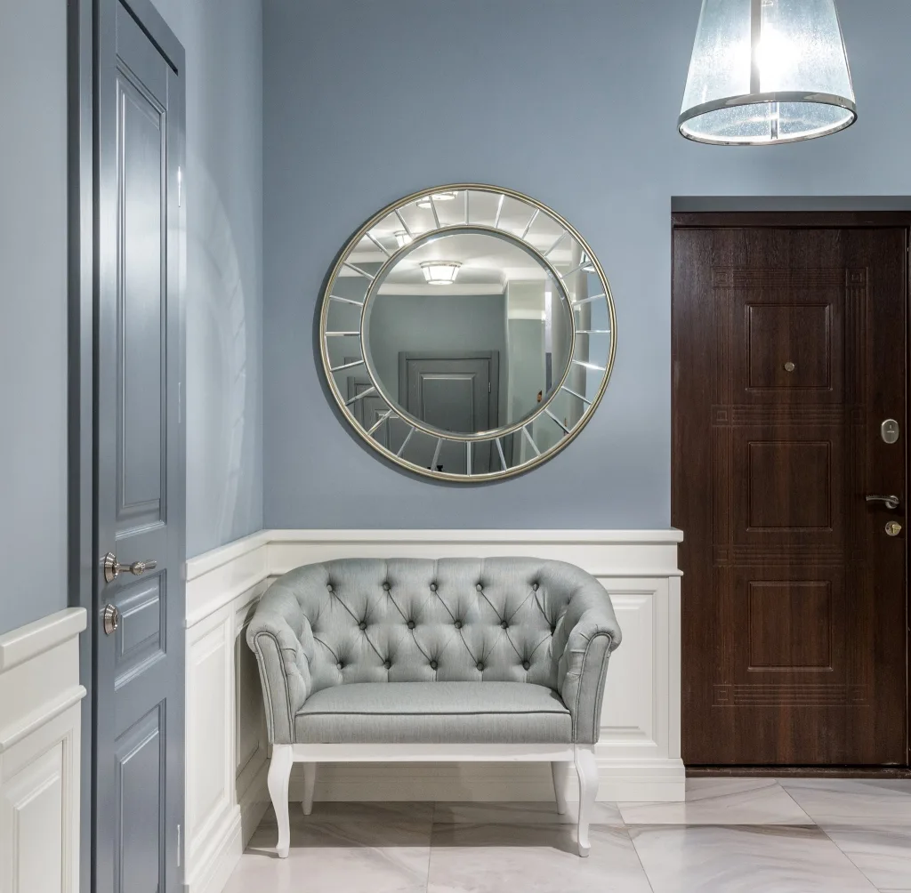 39 VALUABLE ADU IDEAS TO OPTIMIZE SPACE IN A BACKYARD BUILD (700+ PICS) 148 Gray leather armchair placed under stylish round mirror in light corridor with gray walls in contemporary apartment in daytime