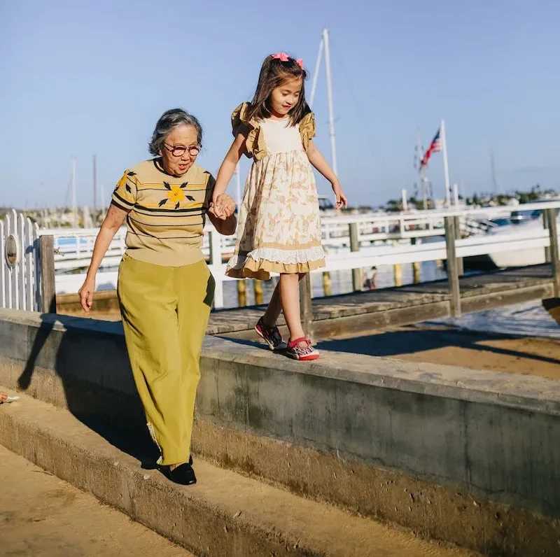 Grandma Holding Her Granddaughter While Walking