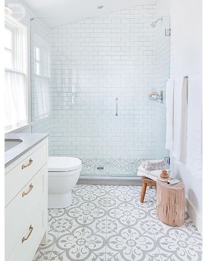 19 SMALL BATHROOM FLOOR TILE IDEAS: ADDING PERSONALITY TO A TINY HOUSE 9 An airy small bathroom with intricate patterned Moroccan-Inspired Tiles, white subway shower tiles, and a touch of natural wood for a clean, serene vibe.