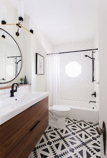 19 SMALL BATHROOM FLOOR TILE IDEAS: ADDING PERSONALITY TO A TINY HOUSE 13 This petite washroom combines stark geometric Patterned Cement Tiles on the floor with classic subway tiles in the shower, anchored by a wooden vanity for contemporary elegance.
