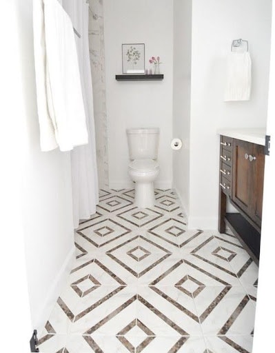 19 SMALL BATHROOM FLOOR TILE IDEAS: ADDING PERSONALITY TO A TINY HOUSE 16 Elegant geometric patterns on the floor enhance this small water closet, blending classic charm with modern sensibility in a compact area.