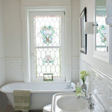 18 SMALL BATHROOM WINDOW IDEAS FOR NATURAL LIGHT AND PRIVACY 4 Elegant bathroom corner with a classic claw-foot tub beneath a stained glass window, surrounded by white subway tiles.