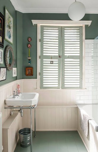 18 SMALL BATHROOM WINDOW IDEAS FOR NATURAL LIGHT AND PRIVACY 6 A quaint bathroom interior featuring a pedestal sink, beadboard wainscoting, and a compact, louvered Shuttered Windows allowing for privacy and natural light.