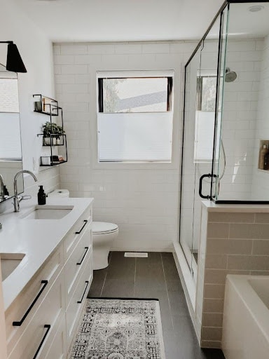 18 SMALL BATHROOM WINDOW IDEAS FOR NATURAL LIGHT AND PRIVACY 8 Modern bathroom with a sleek design, featuring a minimalist vanity, rectangular mirror, and a small Top Down-Bottom Up Shades with a simple white shade above the shower area.