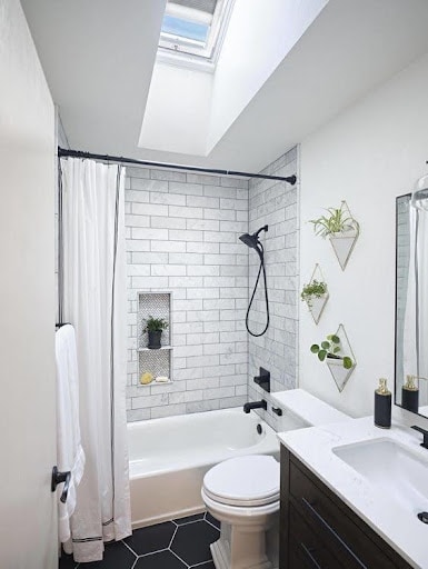 18 SMALL BATHROOM WINDOW IDEAS FOR NATURAL LIGHT AND PRIVACY 15 Bright bathroom featuring a skylight above the tub-shower combo, with subway tiles and black accents creating a modern, clean look.