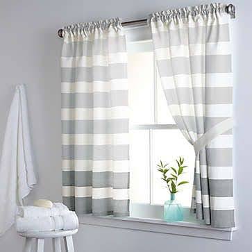 18 SMALL BATHROOM WINDOW IDEAS FOR NATURAL LIGHT AND PRIVACY 17 Simple and elegant bathroom with gray and white striped window Curtains with Tiebacks, adding a touch of design to the unadorned small window."