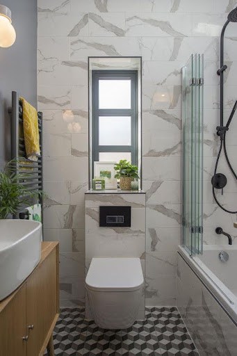 18 SMALL BATHROOM WINDOW IDEAS FOR NATURAL LIGHT AND PRIVACY 20 Narrow, vertical bathroom window providing natural light in a stylish restroom adorned with mixed-pattern tiles and Built-In Shelves with Integrated Windowss.