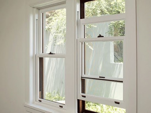 18 SMALL BATHROOM WINDOW IDEAS FOR NATURAL LIGHT AND PRIVACY 23 Double hung bathroom windows with frosted glass for privacy, set in a bright space with a view of lush greenery outside.