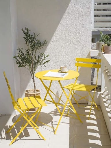 20 SMALL PATIO FURNITURE IDEAS TO MAKE A BIG IMPACT 2 Space-conscious balcony table and chairs set, adding a pop of color to small outdoor areas.