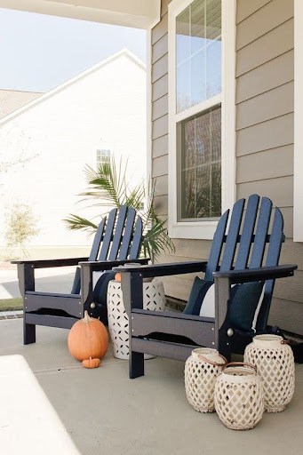 20 SMALL PATIO FURNITURE IDEAS TO MAKE A BIG IMPACT 4 Porch ensemble featuring Adirondack chairs and versatile side stools, ideal for limited patio spaces.