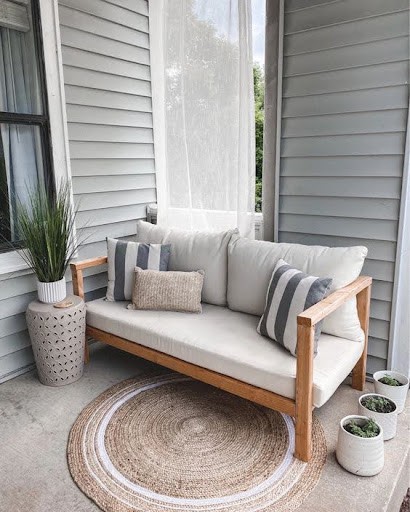 20 SMALL PATIO FURNITURE IDEAS TO MAKE A BIG IMPACT 8 Small space-friendly patio seating arrangement with comfortable loveseat and decorative accessories.