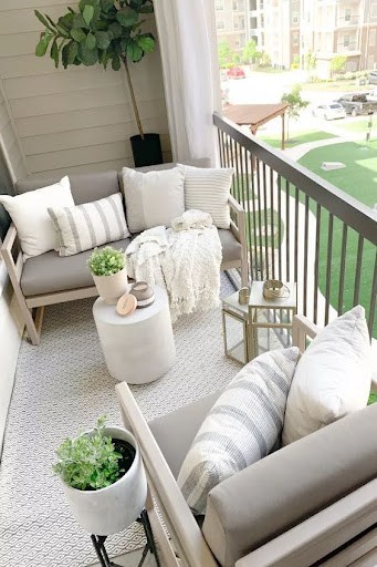 20 SMALL PATIO FURNITURE IDEAS TO MAKE A BIG IMPACT 9 Small space-friendly patio seating arrangement with comfortable loveseat and decorative accessories.