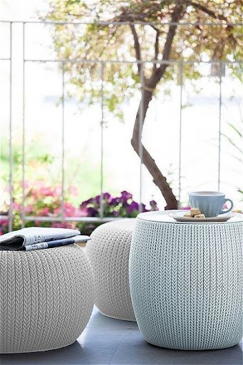 20 SMALL PATIO FURNITURE IDEAS TO MAKE A BIG IMPACT 10 Round knitted Outdoor Ottoman in a balcony setting, doubling as seating or tabletops, showcasing a functional and stylish choice for limited outdoor spaces.
