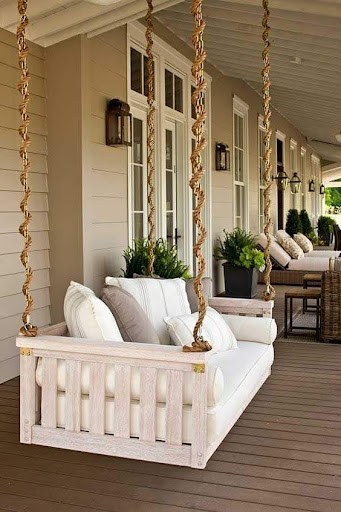 20 SMALL PATIO FURNITURE IDEAS TO MAKE A BIG IMPACT 22 A luxurious porch Hanging Swing Chair with plush white cushions and rope supports, offering an elegant, space-conscious seating option for relaxing outdoors.