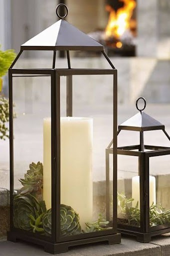 20 SMALL PATIO FURNITURE IDEAS TO MAKE A BIG IMPACT 25 Two large metal lanterns with Addition of Candle Lamp, surrounded by succulents, creating a serene ambiance for a small patio setting.