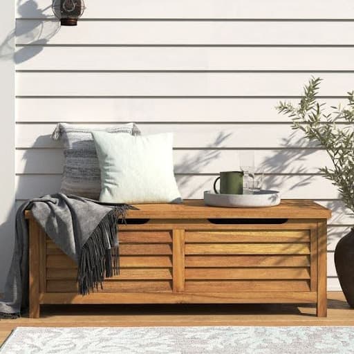 20 SMALL PATIO FURNITURE IDEAS TO MAKE A BIG IMPACT 27 A minimalist patio Portside Outdoor Deck Box with a plush cushion, a soft throw, and a rustic wooden tabletop set against a clean, white wall.