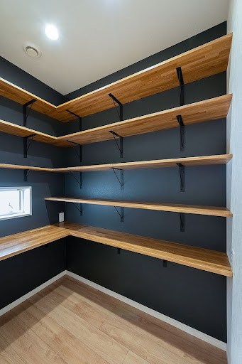 22 AWESOME SMALL WALK-IN CLOSET IDEAS FOR TINY HOMES & ADUS 4 A contemporary walk in closet with bold black walls, wooden shelves, and unique bracket design for an open storage concept.