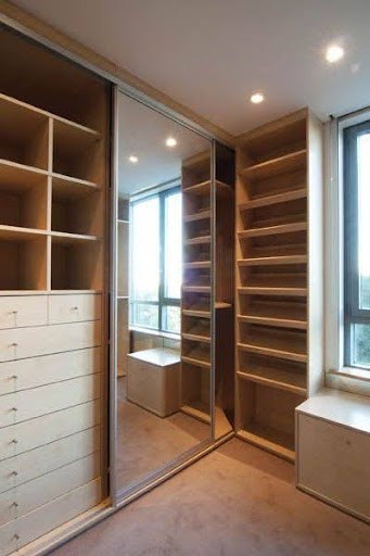 22 AWESOME SMALL WALK-IN CLOSET IDEAS FOR TINY HOMES & ADUS 9 A narrow closet space featuring mirrored sliding doors and built-in shelves with a city view.