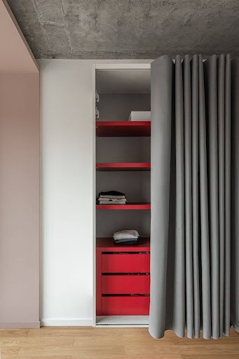 22 AWESOME SMALL WALK-IN CLOSET IDEAS FOR TINY HOMES & ADUS 11 A chic storage nook hidden behind a gray curtain in a modern apartment.