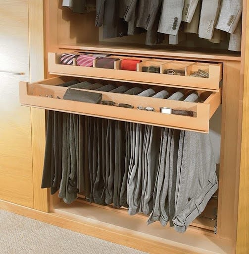 22 AWESOME SMALL WALK-IN CLOSET IDEAS FOR TINY HOMES & ADUS 13 A detailed view of a pull-out trouser rack in a light wood-toned built-in wardrobe.