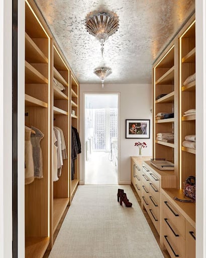 22 AWESOME SMALL WALK-IN CLOSET IDEAS FOR TINY HOMES & ADUS 14 An elegant narrow walk-in closet with luxurious light fixtures and wood accents.