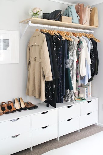22 AWESOME SMALL WALK-IN CLOSET IDEAS FOR TINY HOMES & ADUS 24 A small open closet with a high shelf for bags, a hanging rod, and spacious white drawers beneath.