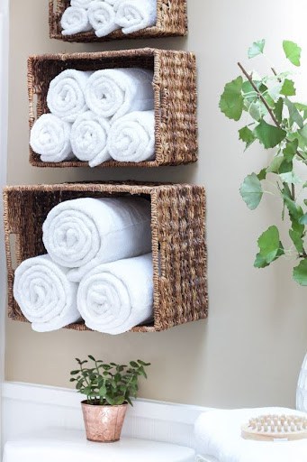 TOWEL STORAGE FOR A SMALL BATHROOM: 19 CREATIVE SOLUTIONS 12 Rolled white towels in hanging wicker baskets, adding a natural element to towel storage in a small space.