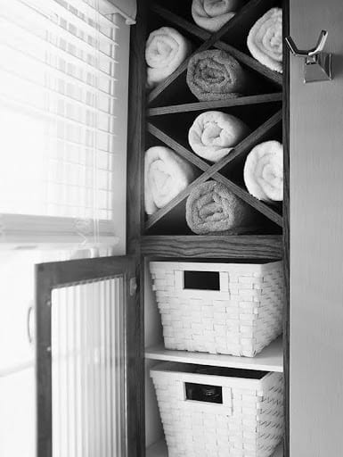 TOWEL STORAGE FOR A SMALL BATHROOM: 19 CREATIVE SOLUTIONS 22 Towels rolled in a Vertical Towel Storage Cabinet: and baskets in a bathroom cabinet, a creative towel storage idea in a small space.