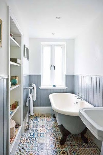 19 SMALL BATHROOM FLOOR TILE IDEAS: ADDING PERSONALITY TO A TINY HOUSE 20 A quaint washroom with vibrant multicolored Colorful Patchwork Floor Tiles and a classic freestanding tub, flanked by wood-paneled walls for a cottage aesthetic.