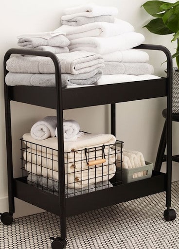 TOWEL STORAGE FOR A SMALL BATHROOM: 19 CREATIVE SOLUTIONS 10 Stacked towels on a rolling cart, providing mobile storage for a small bathroom.