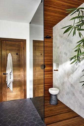 21 SMALL BATHROOM SHOWER IDEAS PERFECT FOR TINY HOUSES & ADUS 21 Modern cozy bathroom shower with dark Teak Wood Accents, and a wall niche, creating a natural and chic atmosphere.