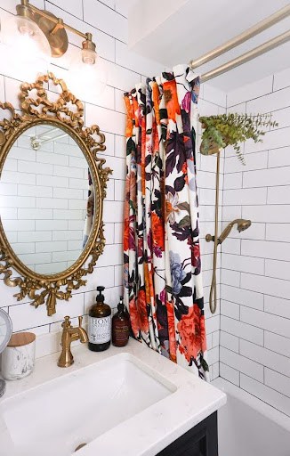 21 SMALL BATHROOM SHOWER IDEAS PERFECT FOR TINY HOUSES & ADUS 22 This small bathroom shower captures a bohemian vibe with its vibrant floral curtain, classic white subway tiles, antique gold mirror, and vintage-inspired brass fixtures.