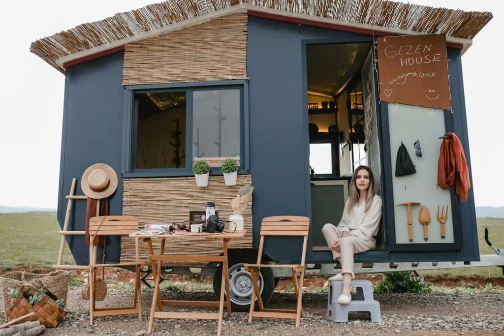 Woman Sitting in a Trailer Converted to a House on Wheels