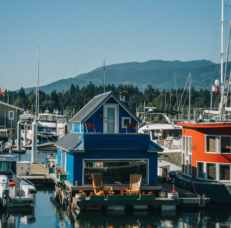 blue red and white houses beside body of water during daytime