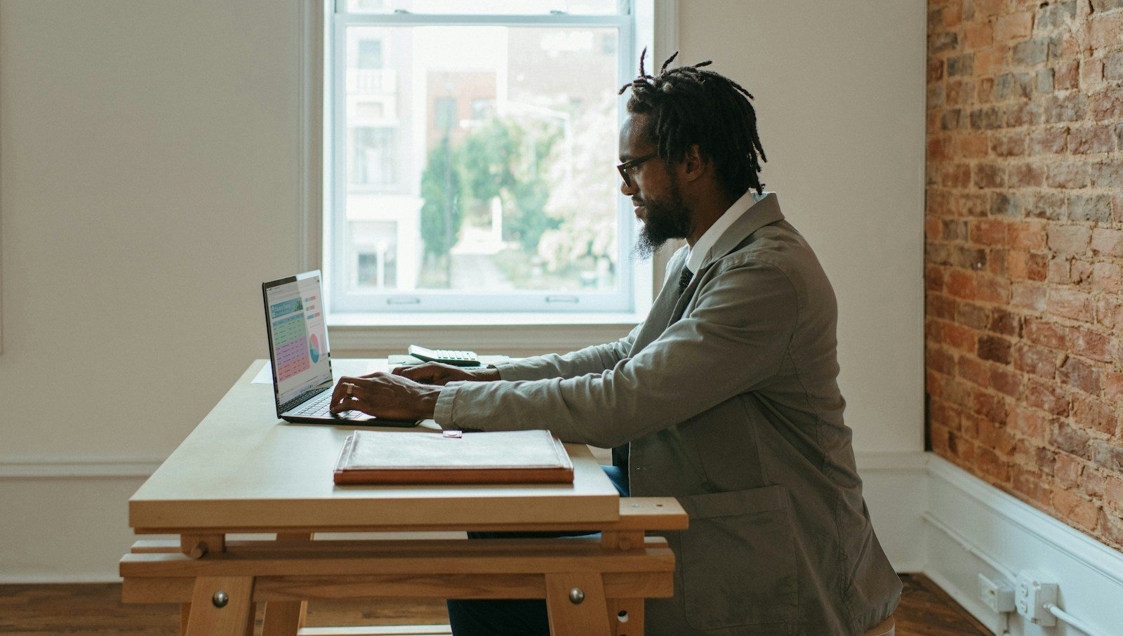 27 INSPIRING GARAGE CONVERSION IDEAS TO ADD LIVING SPACE TO YOUR HOME 9 a person sitting at a desk with a laptop and papers